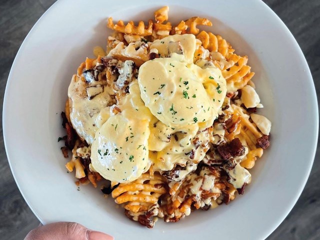 breakfast poutine with waffle fries, poached egg, bacon, and hollandaise